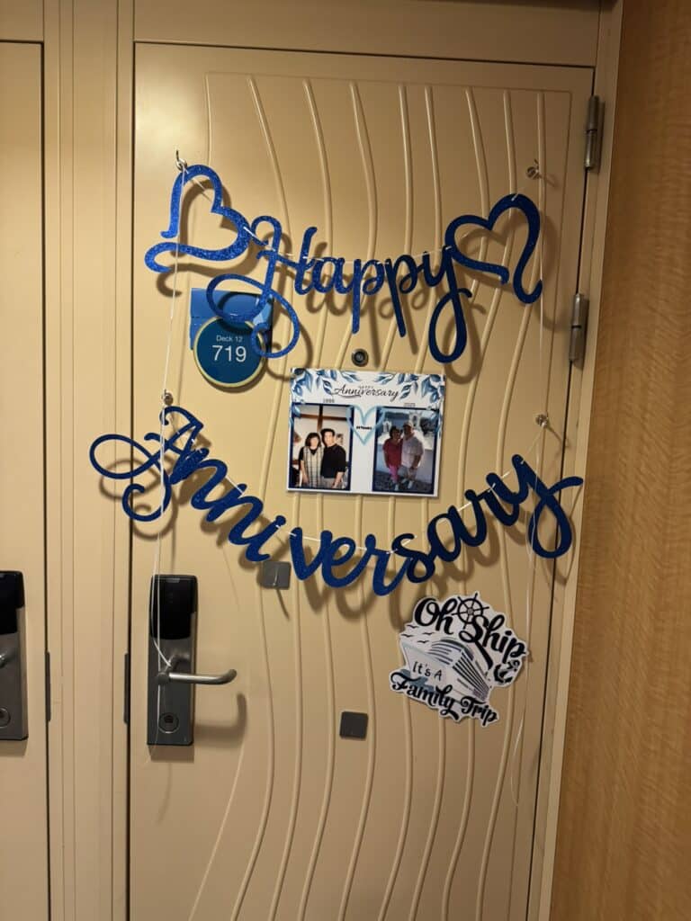 Cruise cabin door decorated with anniversary signs and festive touches, creating a joyful moment that captures the spirit of an anniversary cruise celebration.