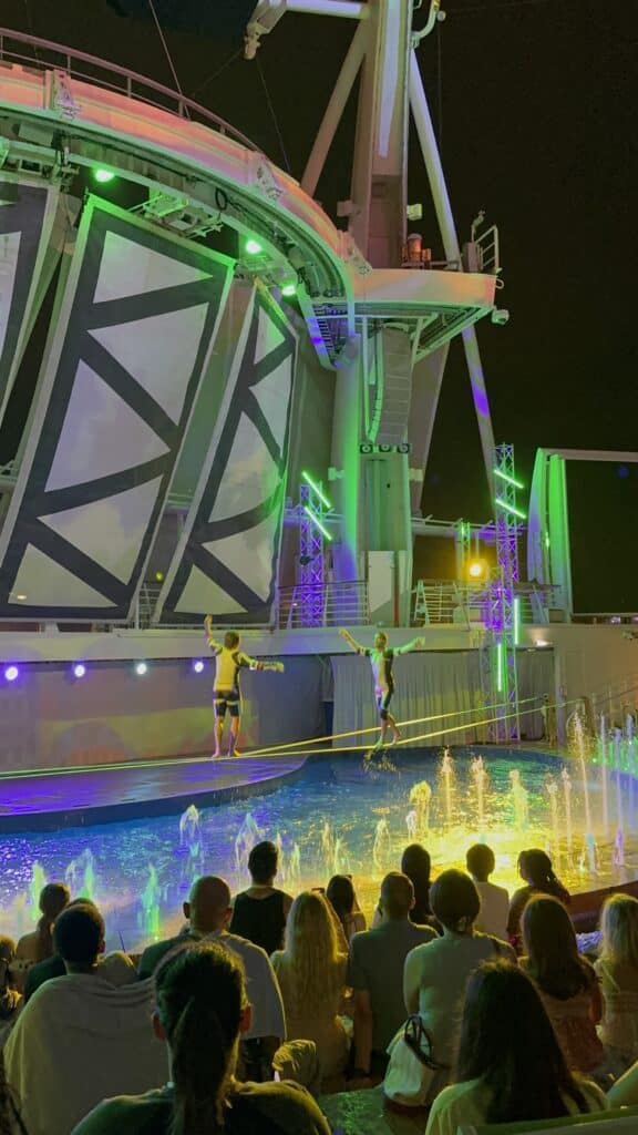 Evening AquaTheater performance on Oasis of the Seas with dancers onstage under dramatic lighting for the Oasis of the Seas guide.
