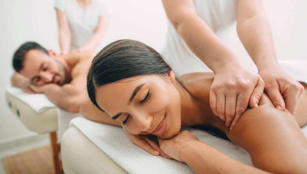Couple enjoying a relaxing side‑by‑side massage in the cruise ship spa, a romantic experience for an anniversary celebration cruise.