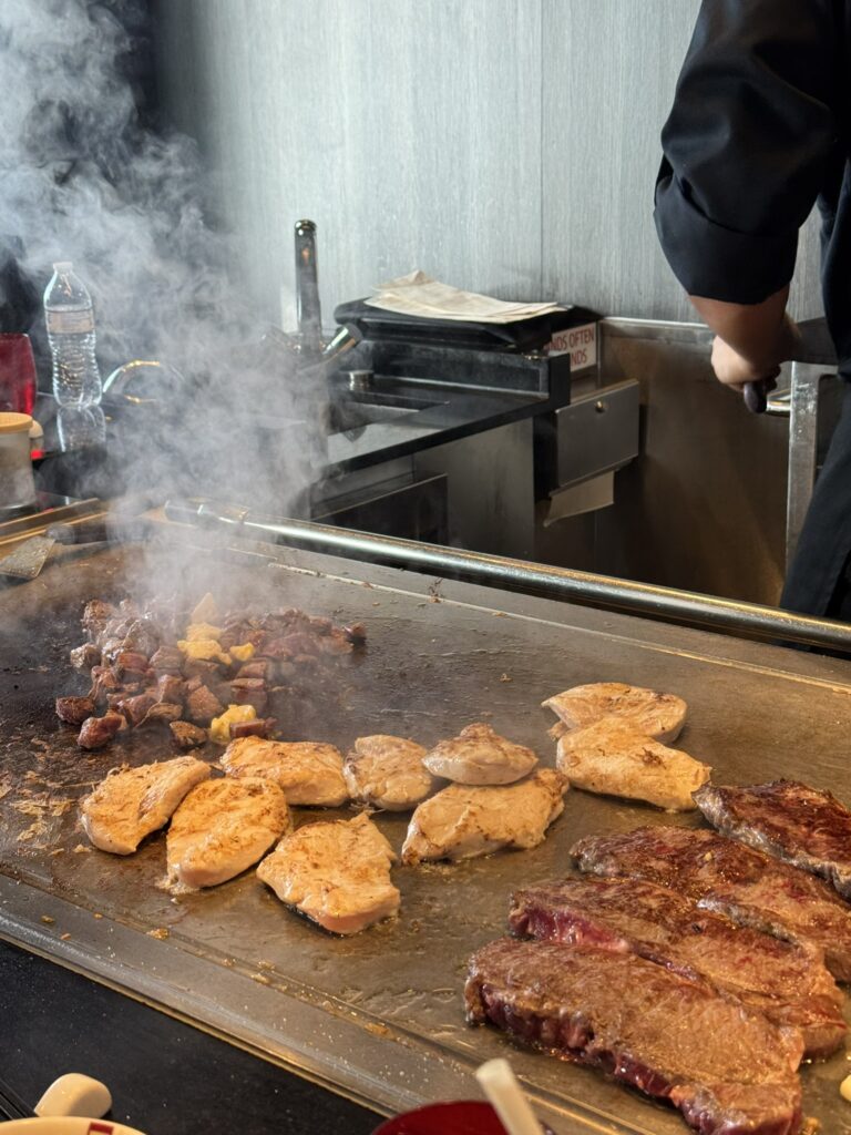 Chef at Izumi preparing dinner at a specialty restaurant as part of a joyful birthday cruise celebration.
