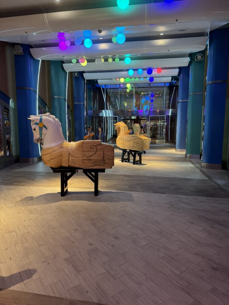 Empty Boardwalk entrance on Oasis of the Seas in the early morning, showing colorful storefronts and a completely quiet walkway.