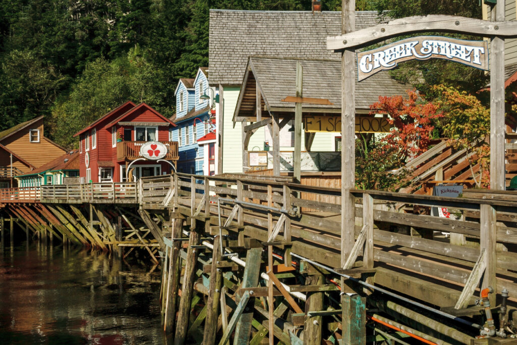 Colorful stilted buildings and the wooden Creek Street archway along the historic boardwalk in Ketchikan, Alaska.