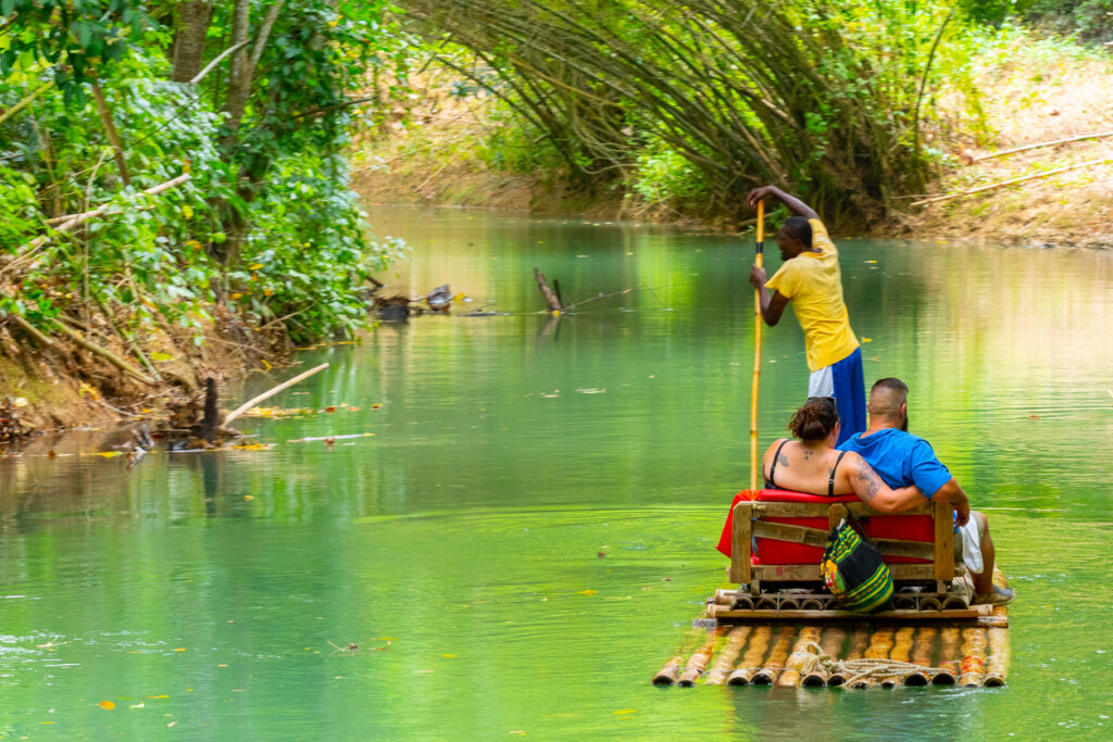 Bamboo raft floating down the Martha Brae River in Jamaica surrounded by lush tropical greenery