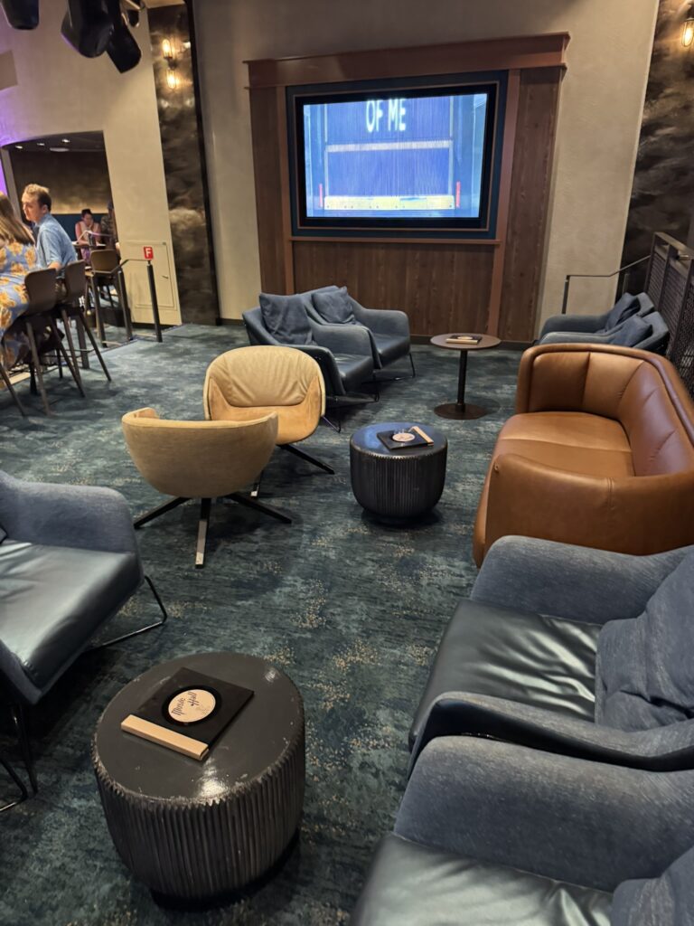 Lounge seating area inside the Music Hall on Oasis of the Seas, featuring modern chairs, warm lighting, and a relaxed atmosphere before the live entertainment begins.