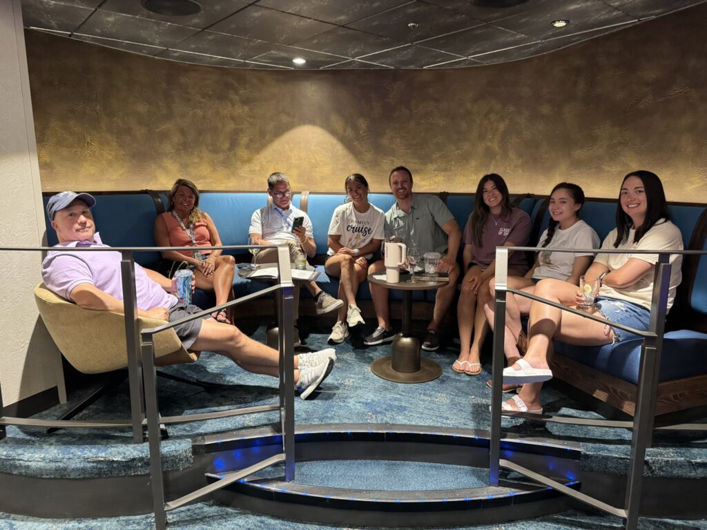 Group of friends seated together in a semi‑circular booth inside the Music Hall on Oasis of the Seas, enjoying drinks and conversation in the lounge-style seating area.