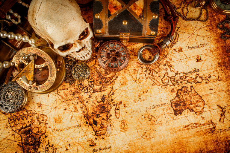 Vintage nautical still life with rope, compass, and aged map representing Nassau’s pirate history