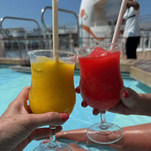 Two frozen drinks enjoyed poolside on a cruise ship, highlighting some of the best cruise cocktails.