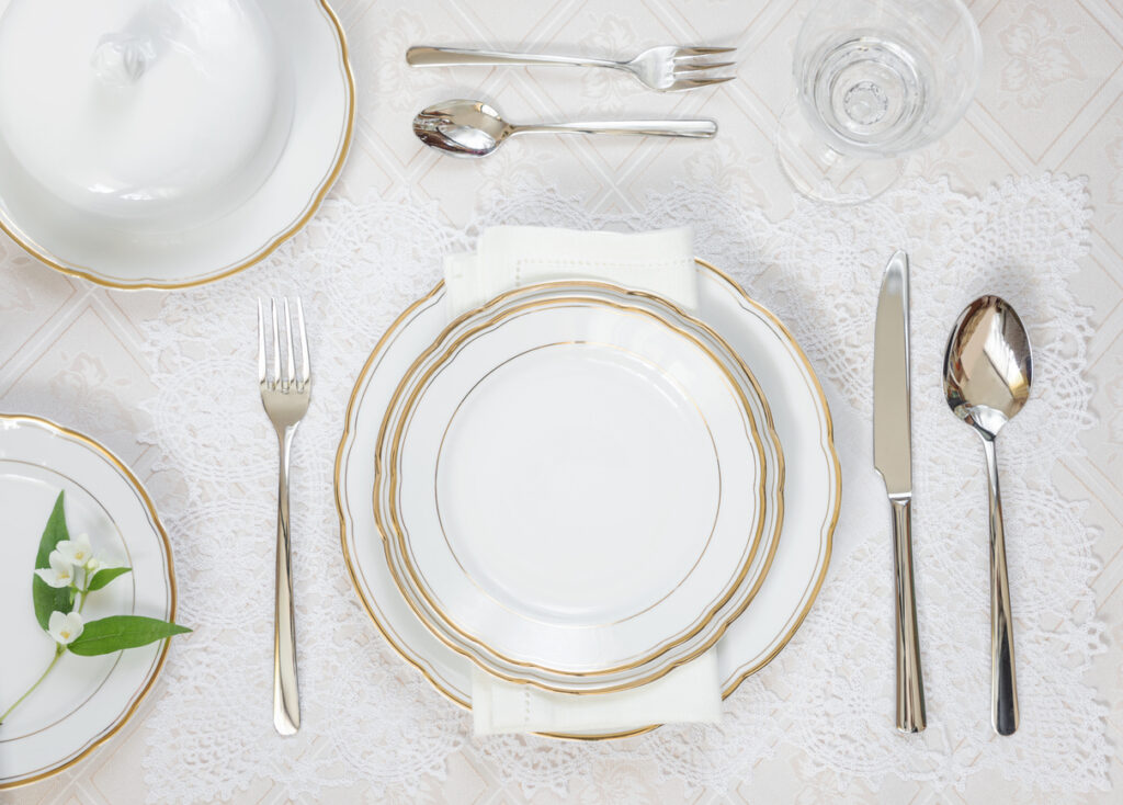 Elegant formal table setting with gold‑trimmed dishes and utensils, illustrating one aspect of cruise ship etiquette.