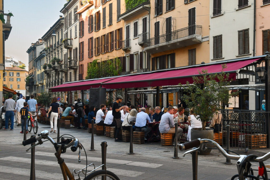 Glimpse of Corso Garibaldi in the Brera district, a popular area known for its lively atmosphere, with an outdoor bar-restaurant crowded with people at sunset, Milan, Lombardy, Italy
