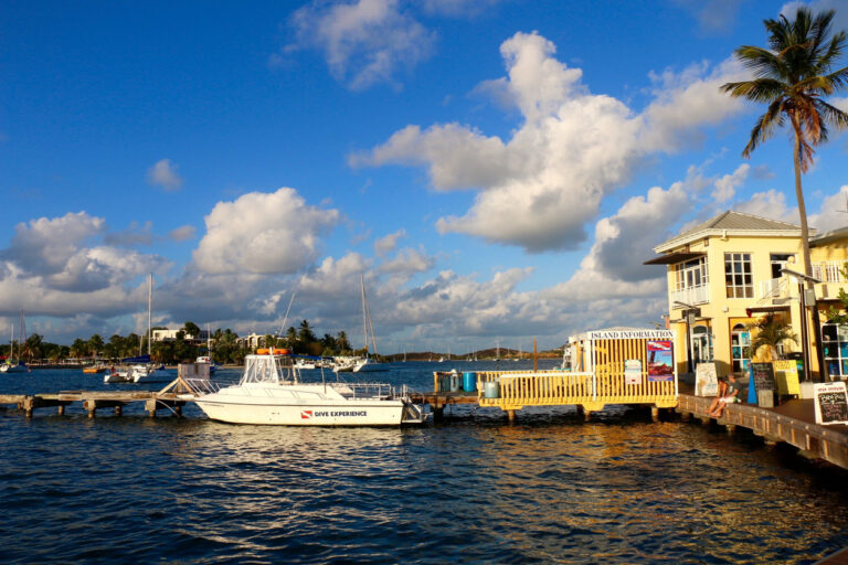 The Christiansted Boardwalk with colorful waterfront buildings and boats anchored in the harbor.