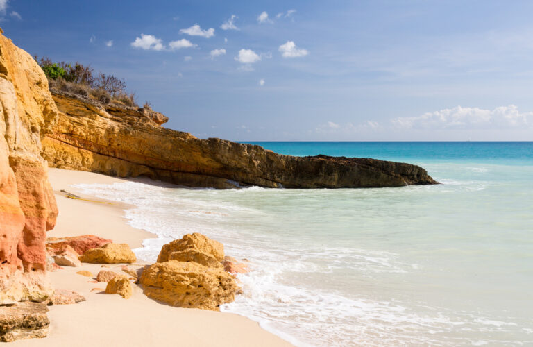 Golden limestone cliffs and small sandy coves along Cupecoy Beach on the Dutch side of St. Maarten.