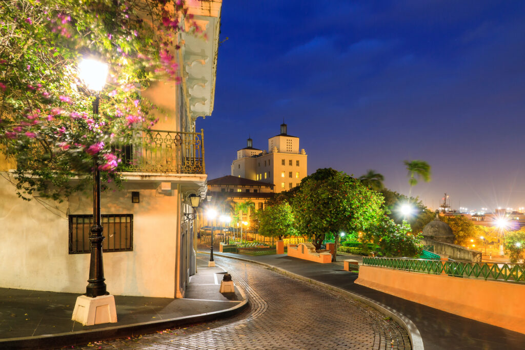 Blue‑hour cityscape of Old San Juan, Puerto Rico, with historic buildings glowing against the evening sky.