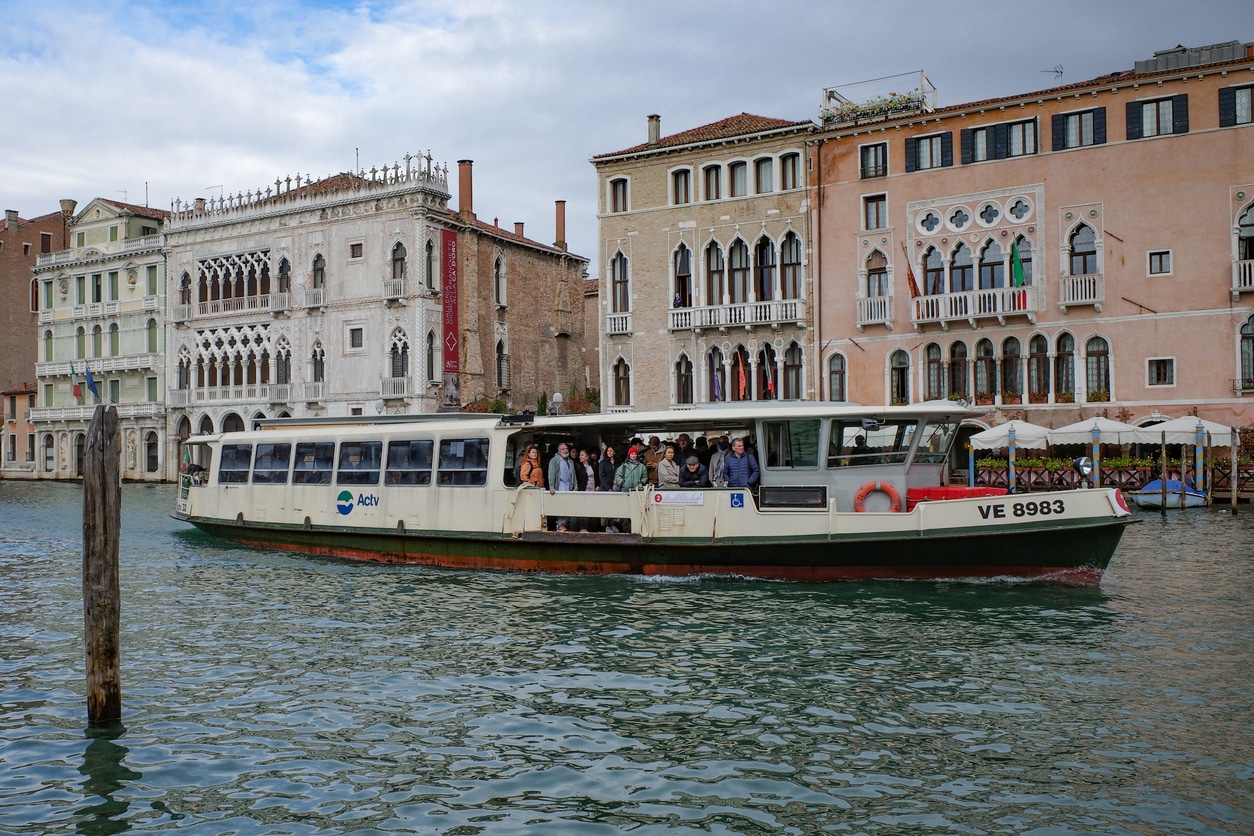Vaporetto cruising along the Grand Canal in Venice with buildings in the background.