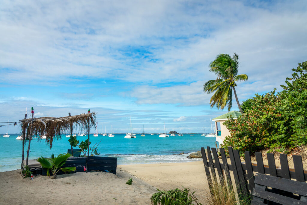 Scenic view of the beach in Grand Case on the French side of St. Martin, with calm water and a peaceful shoreline.