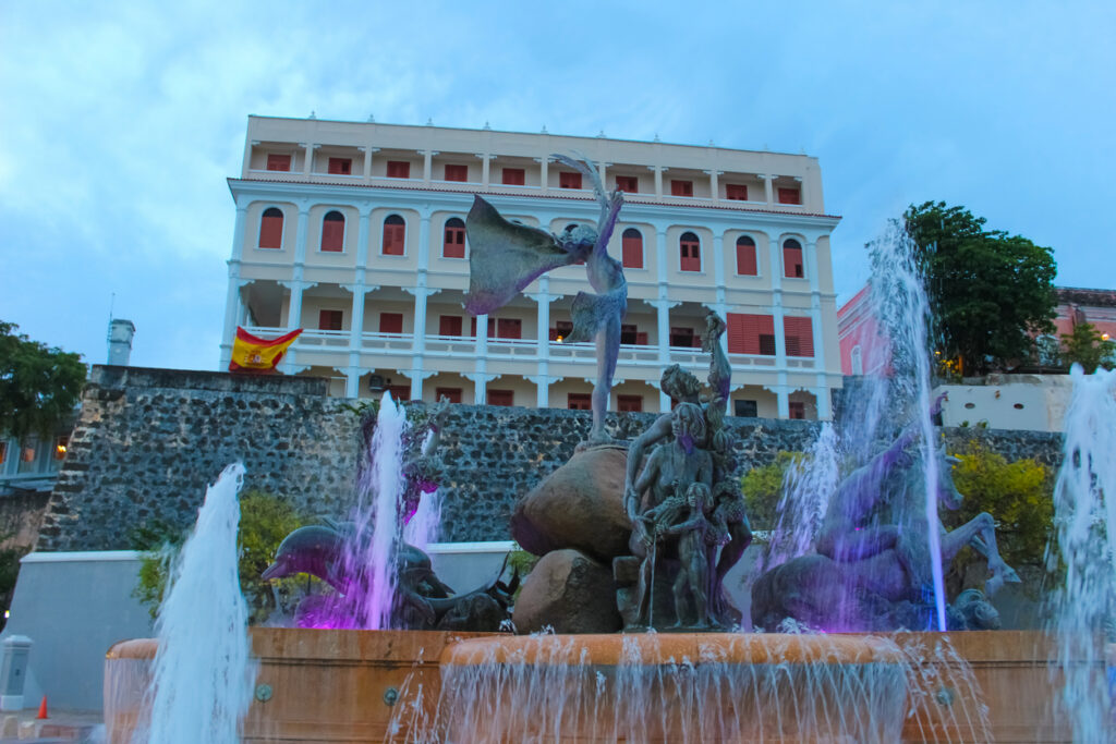 Fountain at Paseo de la Princesa in Old San Juan, Puerto Rico, surrounded by historic walkways and lush greenery along the waterfront promenade.