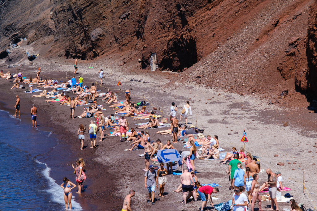 People enjoy Kokkini Paralia (Red Beach) in Santorini, Greece