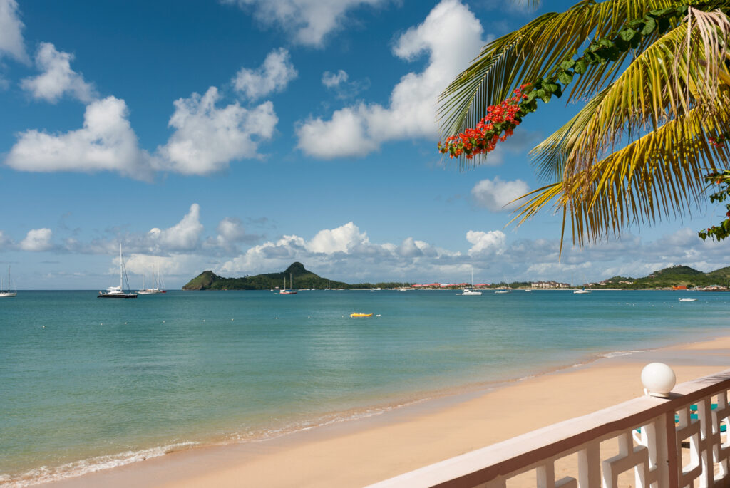 Calm blue water and soft golden sand at Reduit Beach in St. Lucia with views of Rodney Bay.