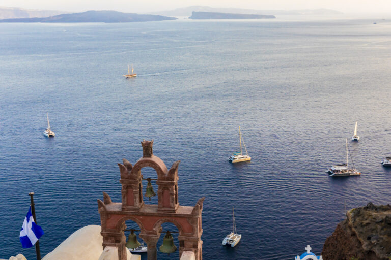 A view of of boats on ocean from Fira, Santorini in the Greek Isles in Thera, Greece