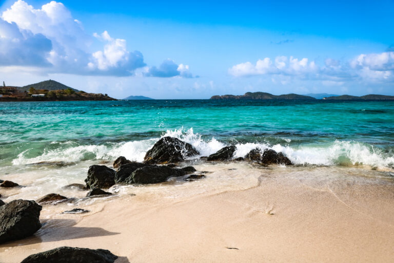 Clear turquoise water and white sand at Sapphire Beach in St. Thomas with views of nearby islands