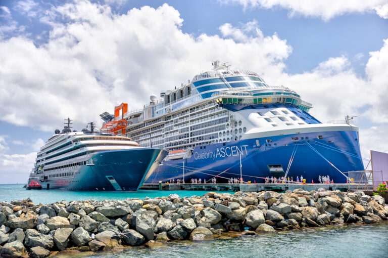 Two cruise ships docked at the Tortola cruise port in the British Virgin Islands with clear Caribbean water and island scenery in the background