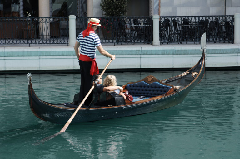 Traditional gondola gliding through a quiet canal in Venice.