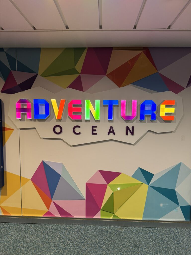 Bright and colorful Adventure Ocean sign marking the entrance to Royal Caribbean’s kids club area