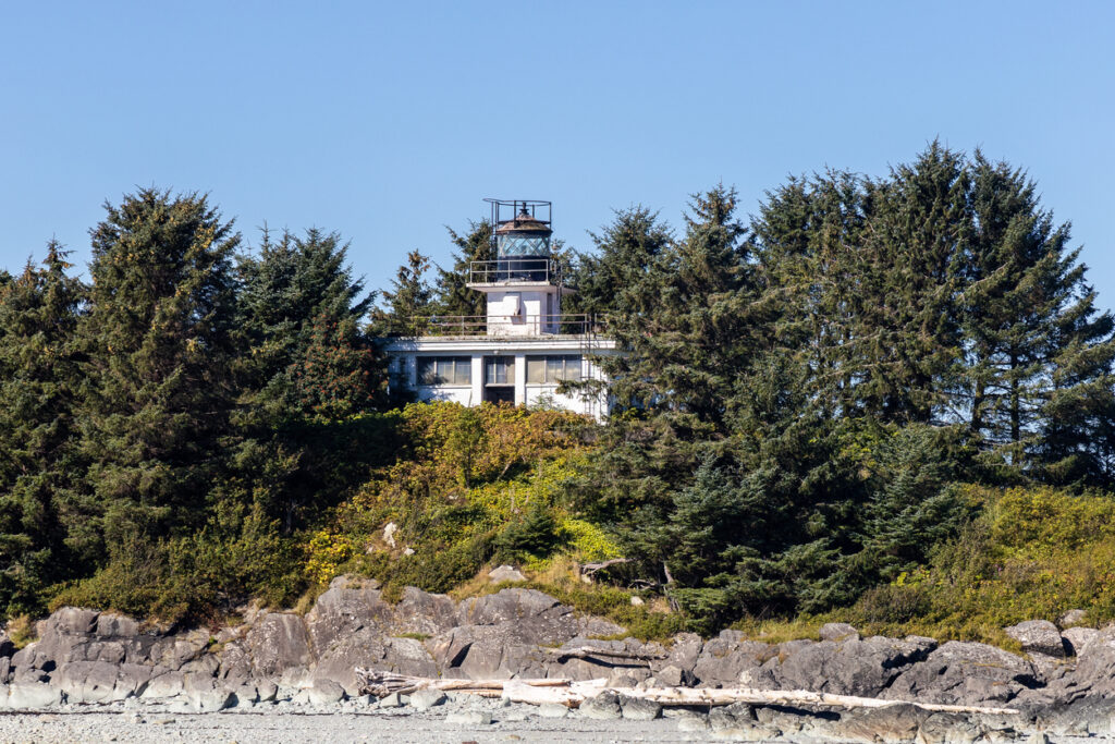 Guard Island Lighthouse on a rocky, forested shoreline at the northern entrance to Tongass Narrows near Ketchikan, Alaska.