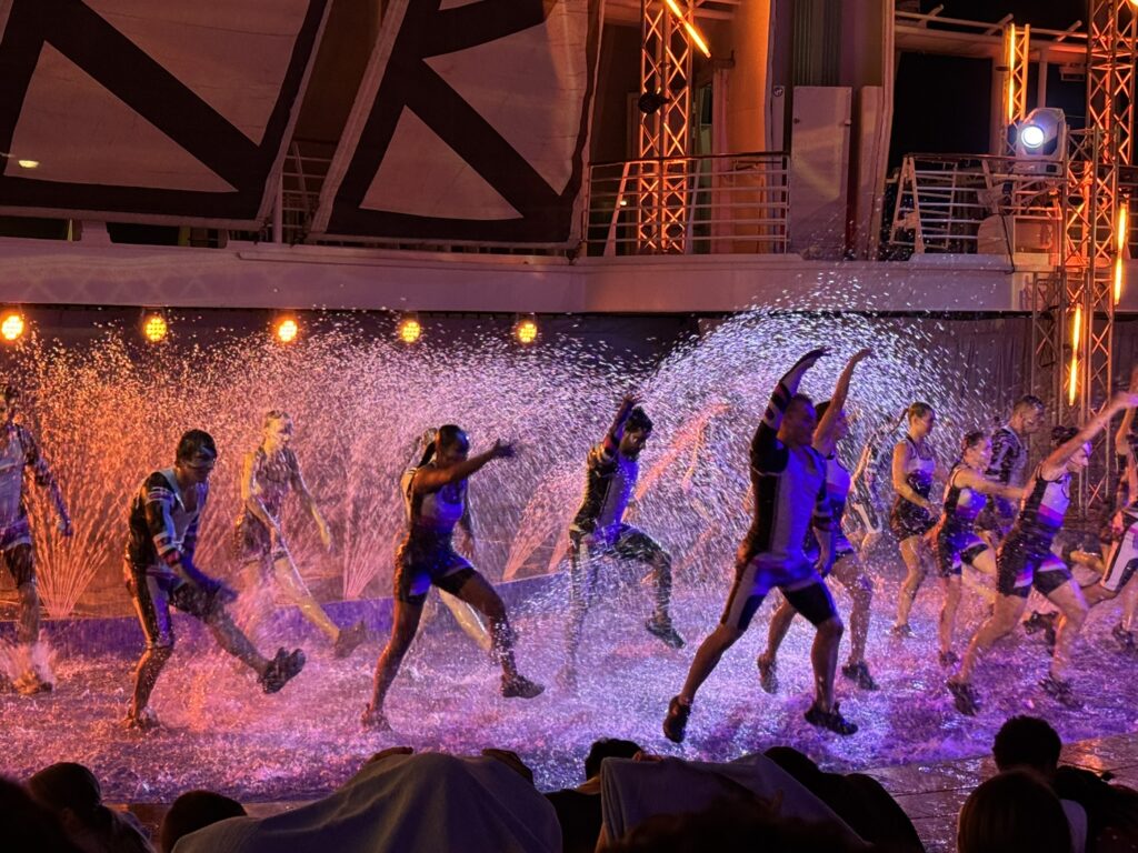 Dancers performing onstage during the AquaTheater show, highlighting one of the best free things to do on a cruise