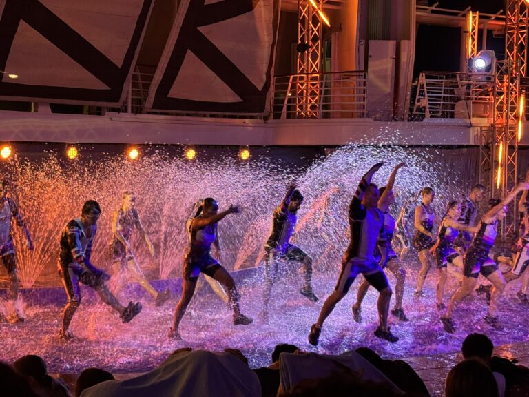 Dancers performing onstage during the AquaTheater show, highlighting one of the best free things to do on a cruise