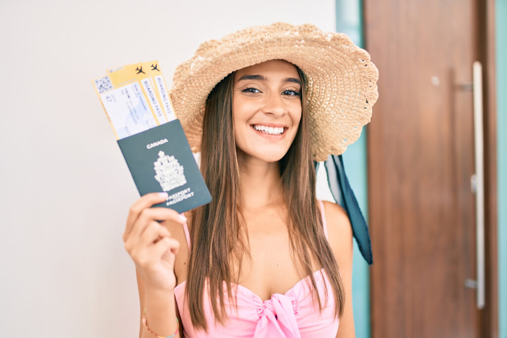 Traveler holding a Canadian passport and boarding passes, illustrating the documents needed for cruise travel and when a passport is required.