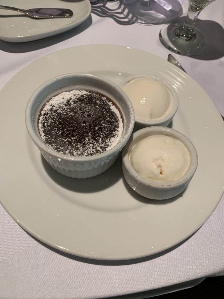 Warm chocolate melting cake with a soft, molten center served with vanilla ice cream on a white plate