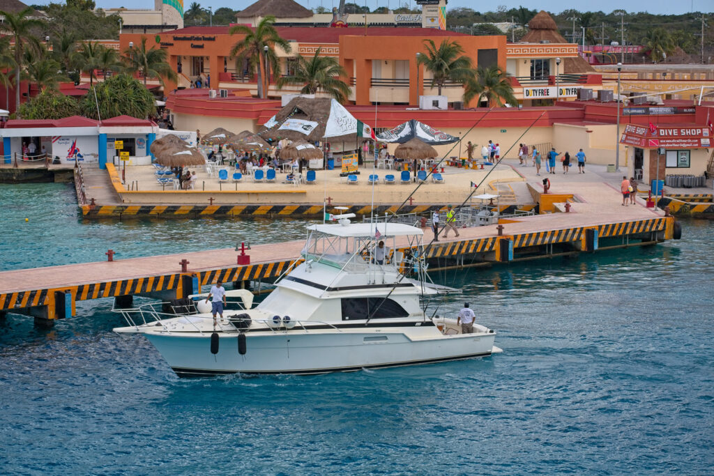 Angler reeling in a catch during a deep‑sea fishing charter in Cozumel.
