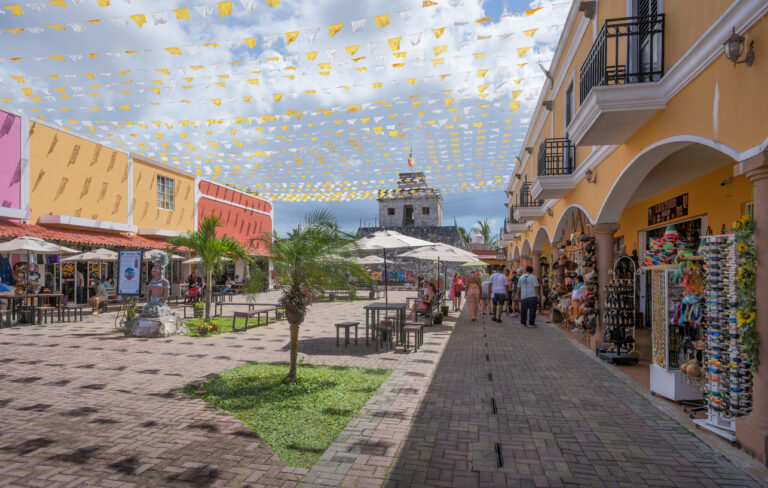Colorful shopping plaza in downtown Cozumel with restaurants, souvenir stands, and colonial‑style architecture.