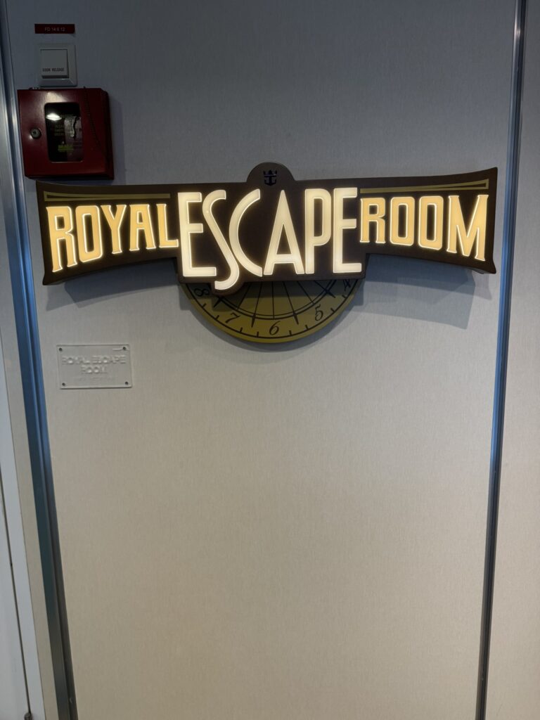 Entrance sign for the cruise ship escape room, featuring illuminated lettering and nautical‑themed design elements.