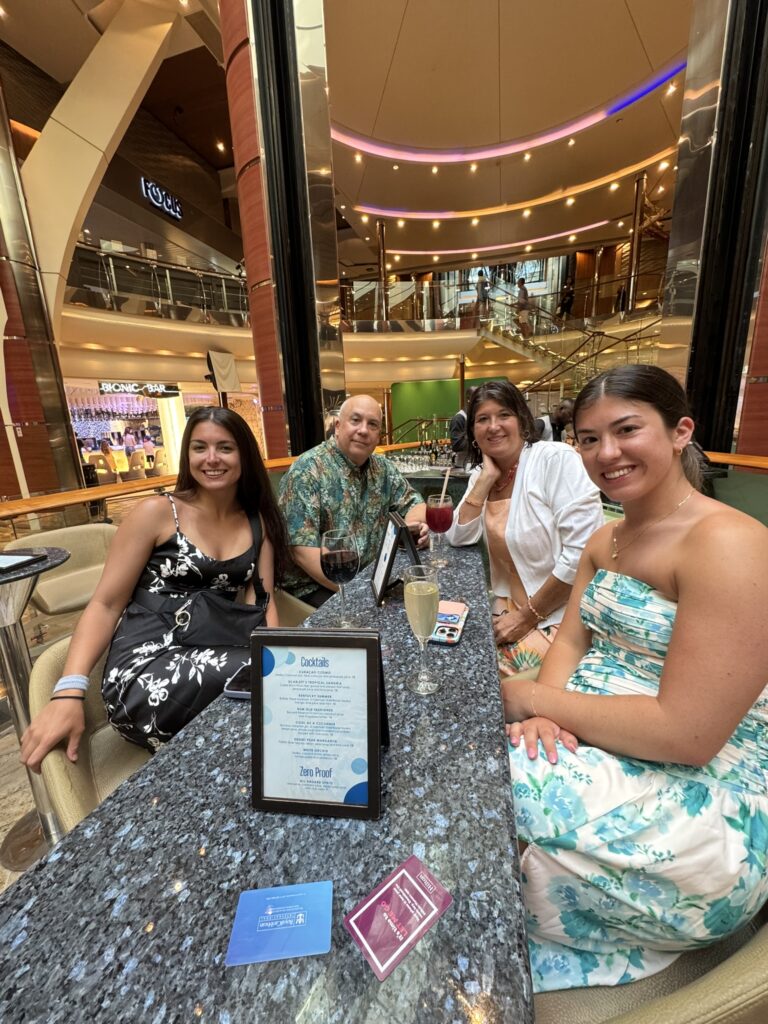 Family enjoying drinks on the Rising Tide Bar with a cruise ship drink package, relaxing without worrying about the bar tab.