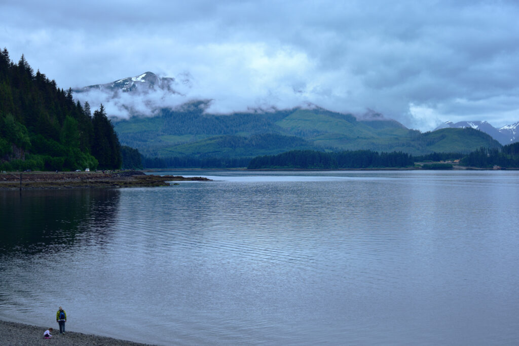 Rocky shoreline at Icy Strait Point near Hoonah, Alaska, with smooth beach stones and coastal scenery along the water.