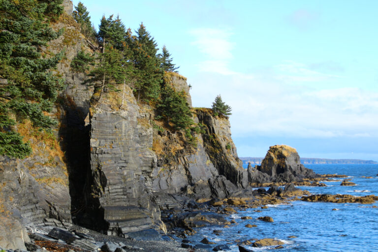 Scenic view of Fort Abercrombie State Historical Park on Kodiak Island, featuring coastal forest and rugged Alaska Peninsula landscape.