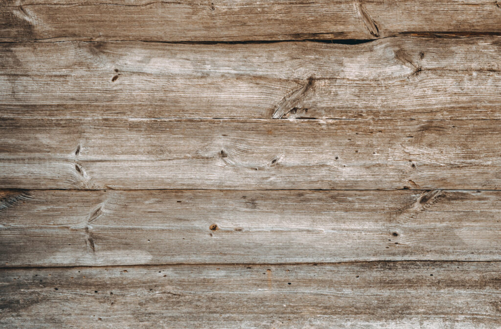 Close‑up of weathered brown‑gray wooden boards with rustic grain and natural texture.