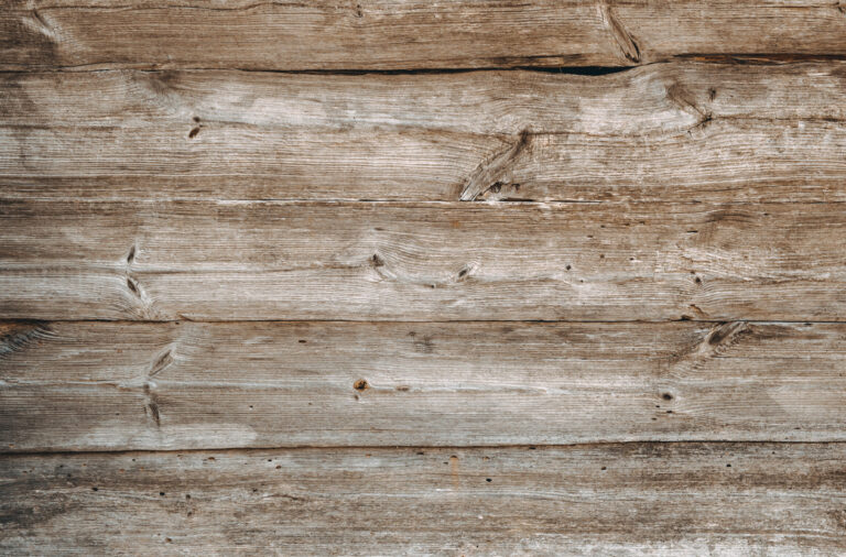 Close‑up of weathered brown‑gray wooden boards with rustic grain and natural texture.