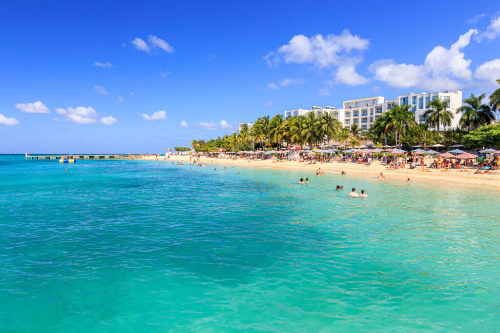 Clear turquoise water and swimmers enjoying Doctor’s Cave Beach in Montego Bay, Jamaica, within the protected Montego Bay Marine Park