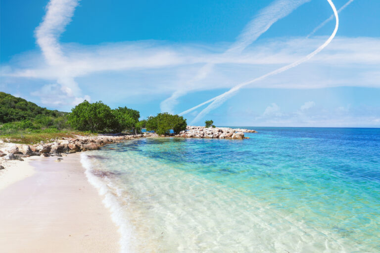 Quiet tropical beach with clear turquoise water and soft white sand, representing the peaceful setting of a private island tour in Jamaica
