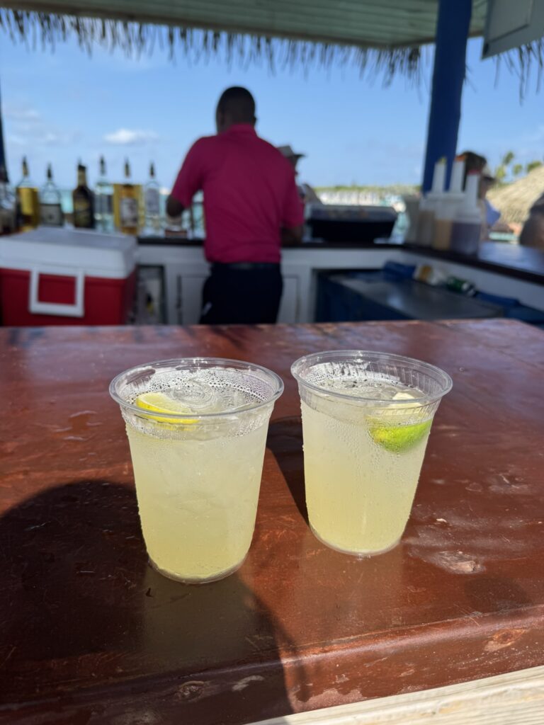 Two tropical drinks sitting on the bar counter at the Floating Bar at Perfect Day at CocoCay
