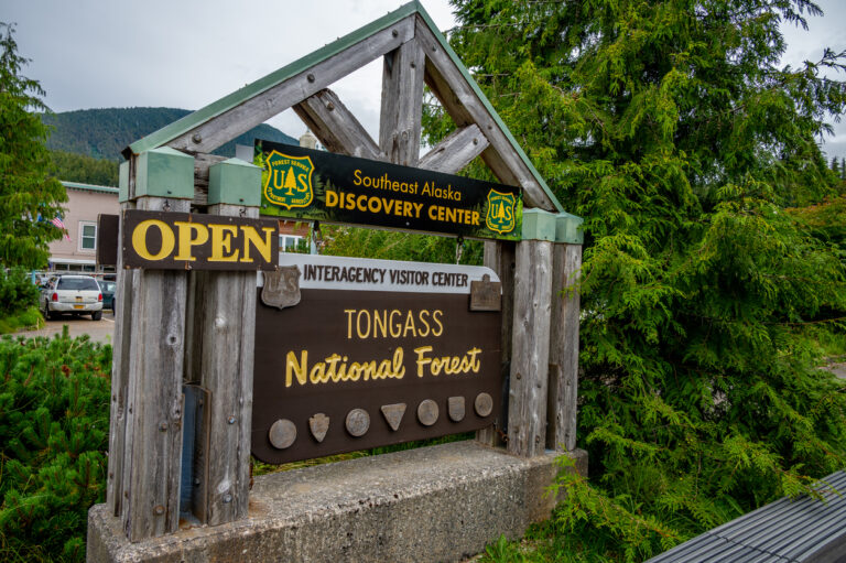 Wooden entrance sign for the Southeast Alaska Discovery Center surrounded by trees in Ketchikan, Alaska.