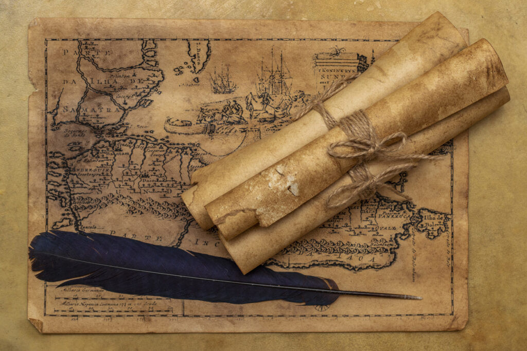 Vintage map and parchment scrolls arranged with a quill, evoking themes of exploration and island history.