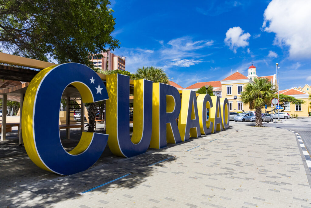 “Welcome to Curaçao” sign in downtown Willemstad with colorful buildings in the background
